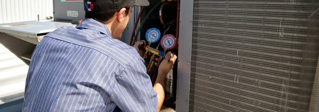HVAC technician servicing a condenser unit in Danville