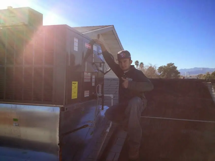 HVAC technician performing HVAC Inspection on a rooftop unit in Danville